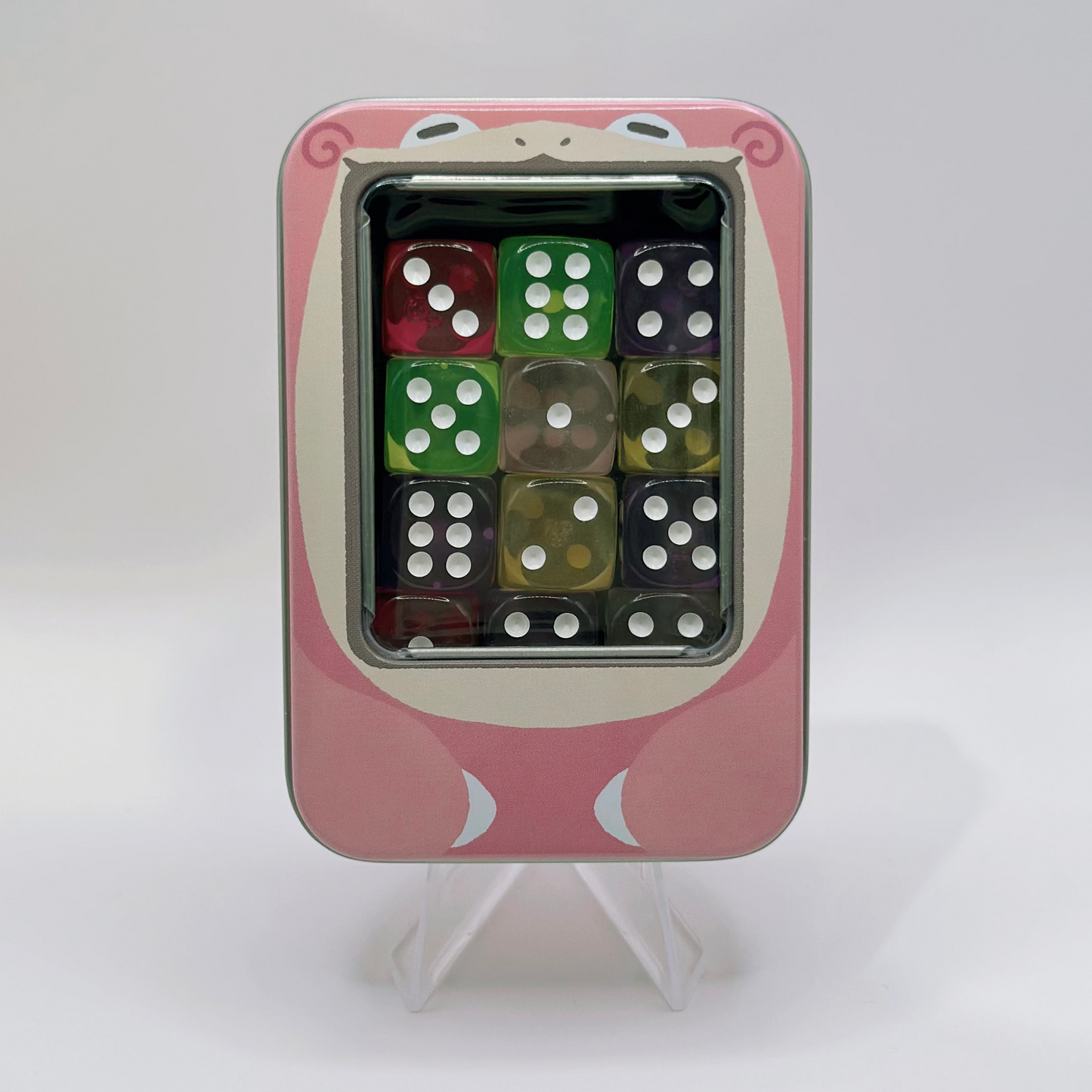 Pink metal TCG dice tin featuring a snoring character design with a clear window and foam insert for 12 dice.