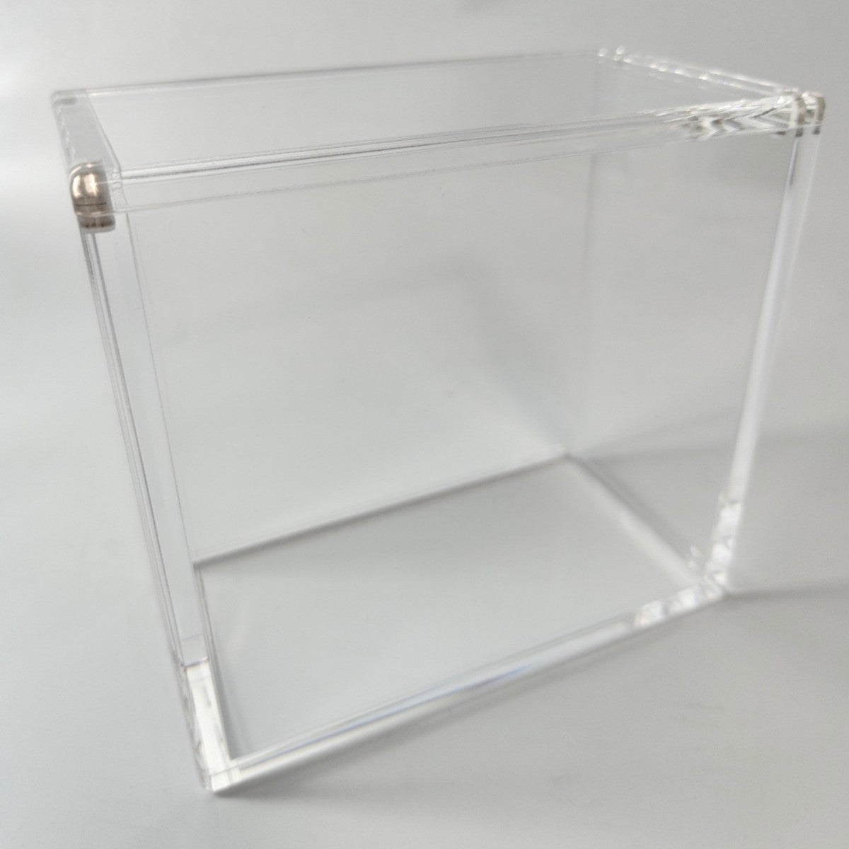 Clear acrylic display case for a booster box, featuring a 2-piece top-opening design with magnetic closure.