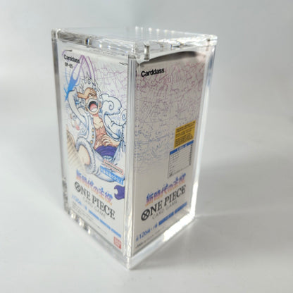 Clear acrylic display case protecting a One Piece TCG booster box, showing its top-opening magnetic closure.