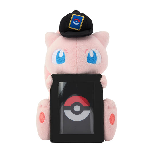 Soft pink Mew plush wearing a black cap, holding a vertical black display frame for a Pokémon trading card.