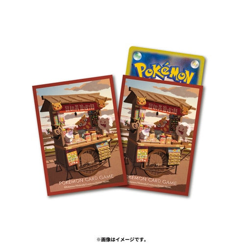 Two red Pokémon card sleeves with a street vendor cart design at sunset, one with a card inserted.