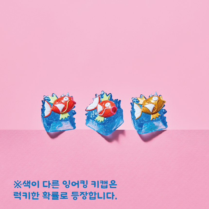 Three Magikarp Pokémon keycaps featuring red and gold fish figures atop translucent blue water-textured bases.