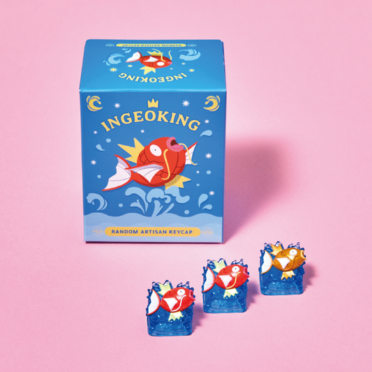 Blue Pokémon Magikarp blind box with three artisan keycaps featuring red and gold fish designs on blue water bases.