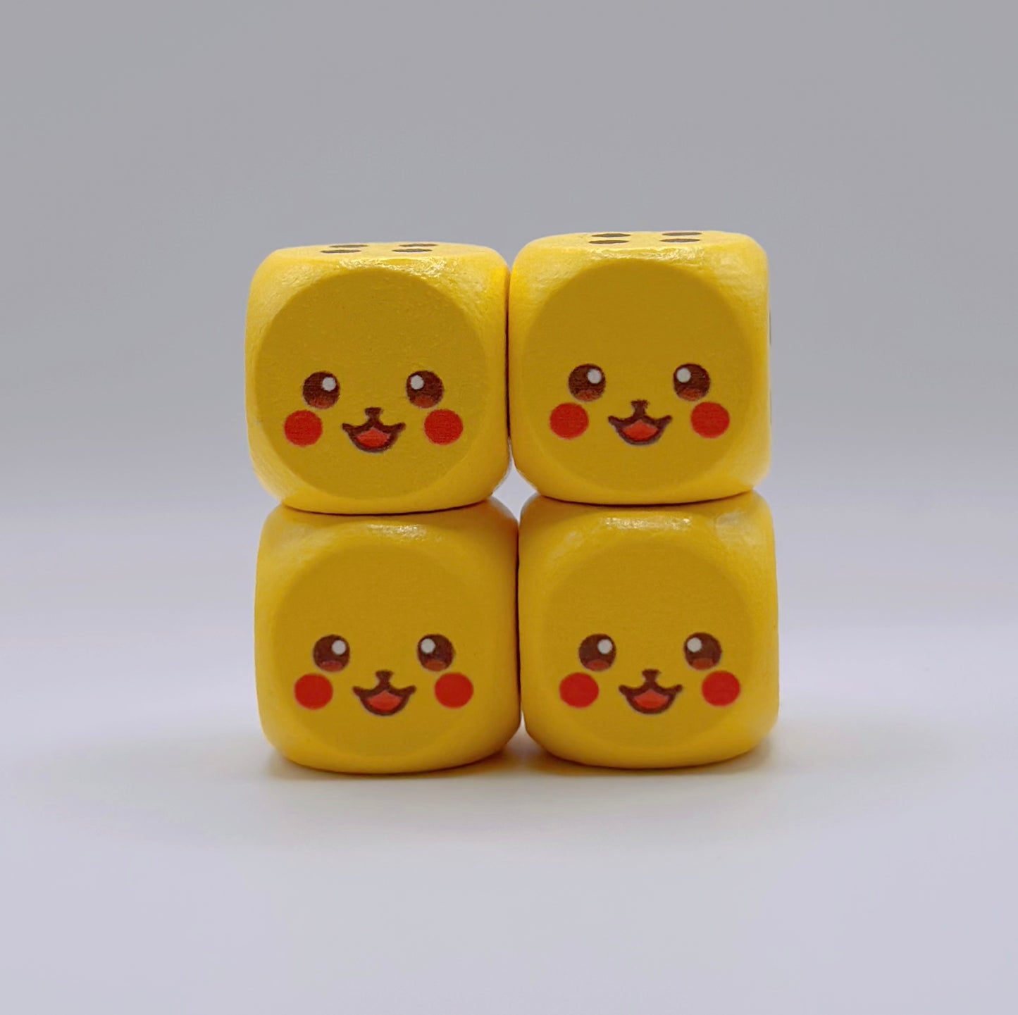 Four yellow 16mm wooden TCG dice featuring a custom Pikachu-inspired face design on the number one side.
