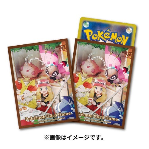 Two Pokémon Card Game Serena sleeves featuring Serena, Fennekin, and other Pokémon, with a Pokémon card visible behind.